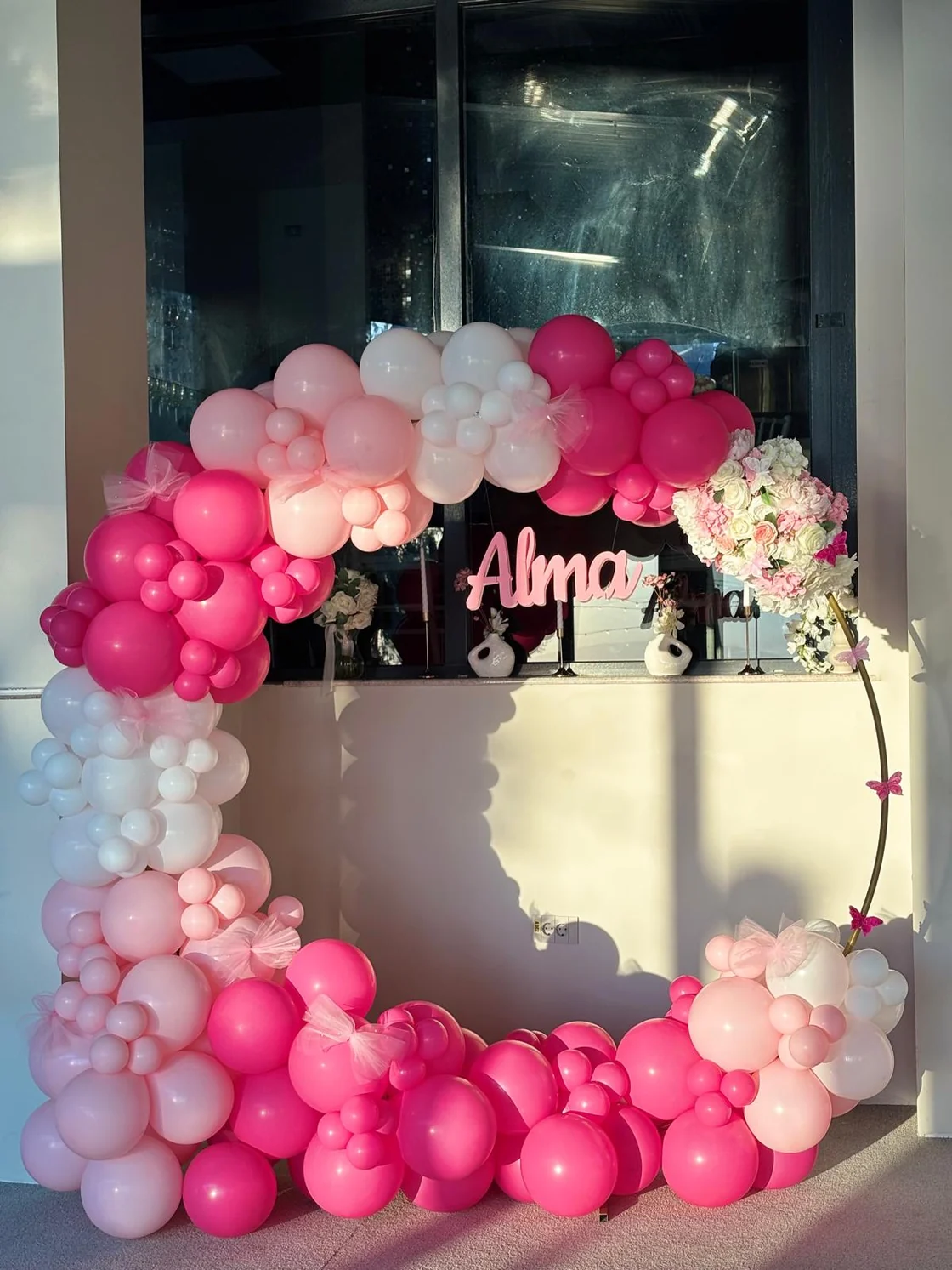 Fotografie originală a arcadei Alma în interior, cu baloane fuchsia, roz și albe.